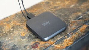 Ein schwarzer, tragbarer Sky WLAN-Hotspot auf einer strukturierten Oberfläche.