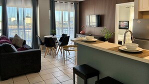 A modern apartment with a dining area, kitchenette, and a sofa. - Ultimate Remodeled 2BR Condo at Enclave Suites (Orlando)
