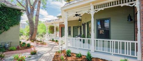 A row of houses with white front porches and green siding.