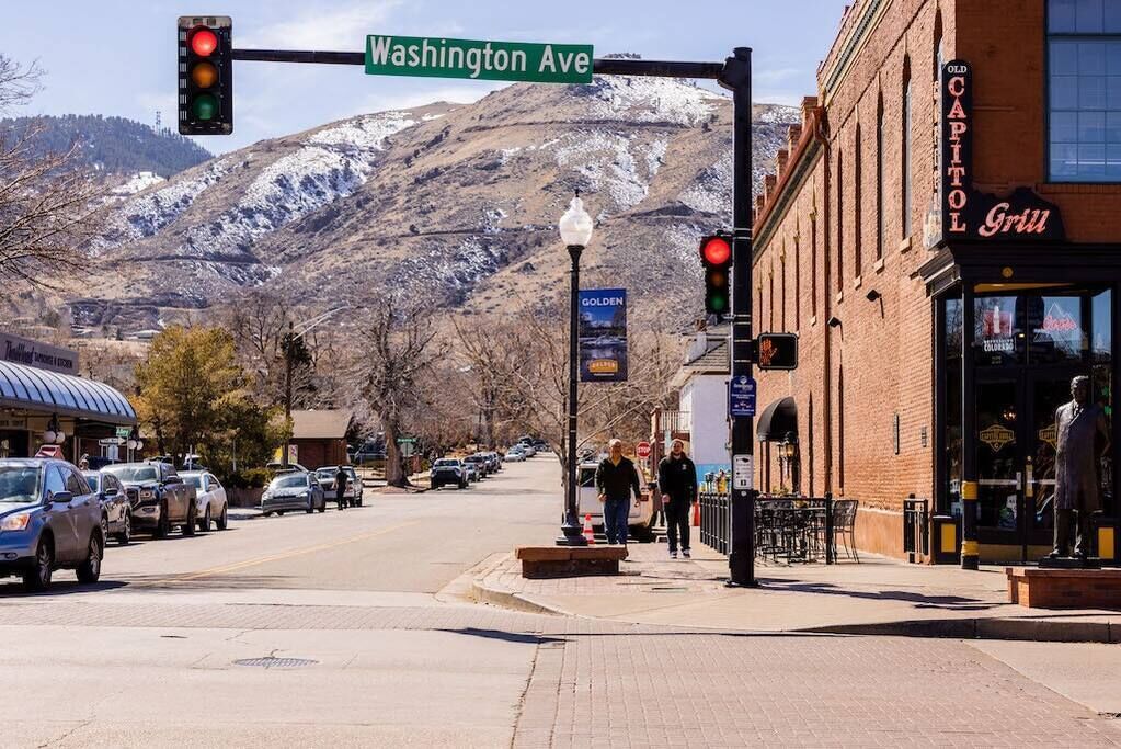 Une vue de rue avec, à droite, un restaurant appelé « Old Capitol Grill », une montagne en arrière-plan et un feu de signalisation à l’intersection de Washington Avenue.