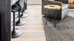 A modern kitchen with a central island, bar stools, a leather sofa, and a round wooden table. - The Golden House | 1 Block to Main St (Golden)