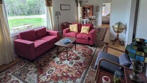 A living room with a red sofa set, a coffee table, and a patterned rug.