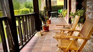 A covered outdoor seating area with wooden chairs and potted plants. - Gîte casa lara with swimming pool lagunas (San Martín de valdetuejar)