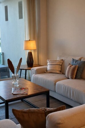 Ein Wohnzimmer mit einer Couch, einem Couchtisch, einer Lampe und einer Zeitschrift.