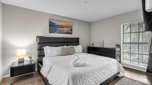 Un dormitorio moderno con una cama grande, una mesita de noche, una lámpara y una repisa en la pared, además de una ventana con persianas.