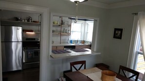 A kitchen with a built-in oven, a refrigerator, and a window above the sink.