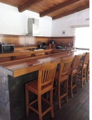 A kitchen with a wooden countertop, a microwave, and a coffee maker. - CABERNET CABANA CABERNET PINOS DEL RIO NEXT TO UMA CACHOEIRA (Mazamitla)