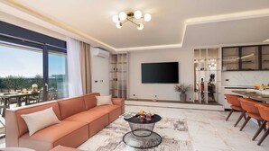 Ein modernes Wohnzimmer mit einer Eckcouch, einem Couchtisch und einem Essbereich mit Stühlen und einem Tisch.