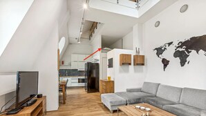 A modern living space with a grey sofa, wooden coffee table, and a TV on a wooden stand.
