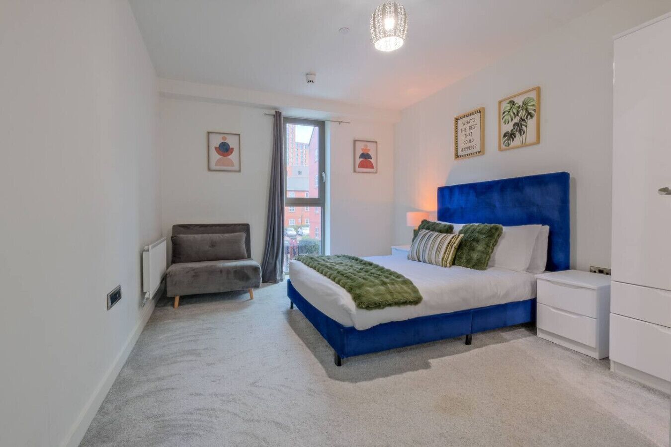 A bedroom with a bed, a chair, a nightstand, and a wardrobe.