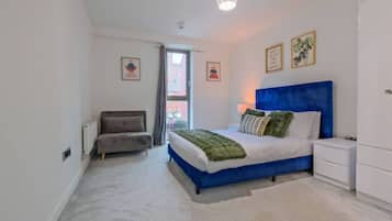 A bedroom with a bed, a chair, a nightstand, and a wardrobe.