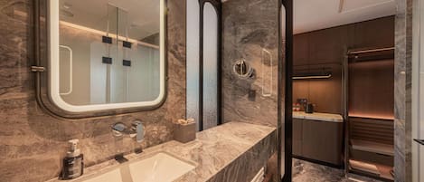 A modern bathroom with a large mirror, a sink, and a shower area.