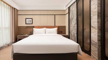 Een moderne hotelkamer met een groot bed, een nachtkastje en een wandtelefoon.