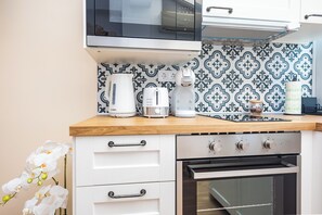 Eine Küche mit Mikrowelle, Kaffeemaschine, Toaster und Backofen.