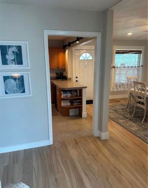 A hallway leading to a kitchen with wooden cabinets and a built-in bookshelf. - The Blue Retreat in Fort Myers Beach (Fort Myers Beach)
