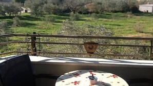 A balcony with a table set for dining, overlooking a green landscape with trees and buildings. - Apartments Lighthouse -(A4) - TwoBedroom Apartment with Sea View (Fazana)