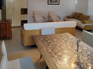 A living room with a sofa, two chairs, a wooden table, and a cabinet. - Apartments Lighthouse - (A5) ThreeBedroom Apartment with Private Garden (Fazana)