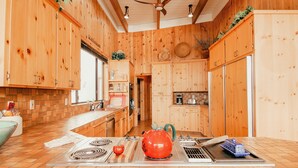 Una cocina moderna con armarios de madera, una isla central y un ventilador de techo.