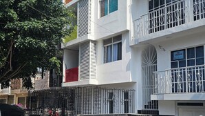 A multi-story residential building with balconies, a gated entrance, and a staircase leading to the entrance. - Perfect 3-bedroom apartment in welcoming Cali neighborhood (Cali)