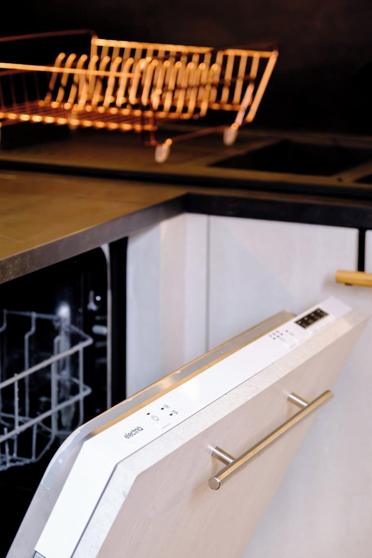A dishwasher with a control panel and a metal rack above it.