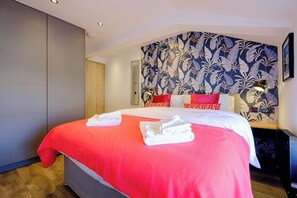 A hotel room with a bed, a nightstand, a lamp, and a patterned wallpaper. - James Court Llandudno Luxury Apartment 7 & Parking (Llandudno)
