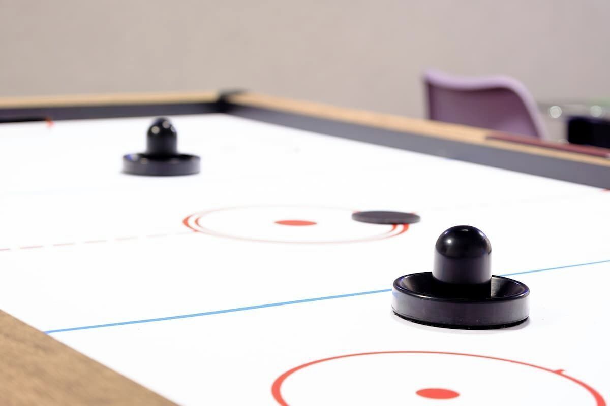 A table with a puck and a stick, likely for a game of foosball.