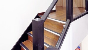 Eine Treppe mit einer Holzhandläufe und einem gerahmten Bild an der Wand.