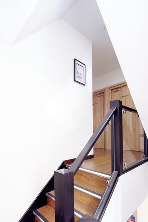 A staircase with a wooden handrail and a framed picture on the wall. - Curzon a family & Pet friendly house with Hot Tub (Conwy Principal Area)