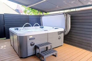 A hot tub with steps, a covered patio, and a wooden deck. - Curzon a family & Pet friendly house with Hot Tub (Conwy Principal Area)