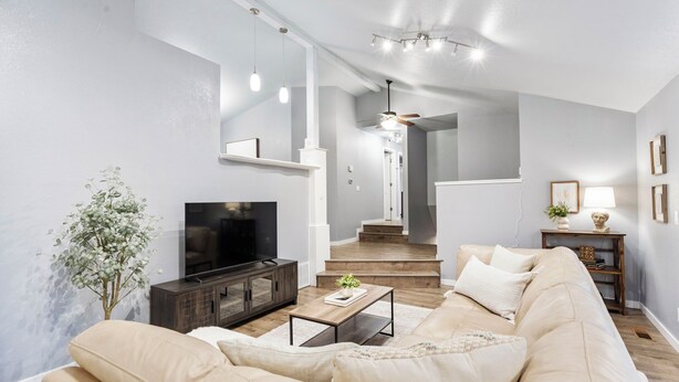 A modern living room with a beige sofa, a wooden coffee table, and a TV on a dark cabinet. - Two Living Spaces • Private Downstairs Suite (Grants Pass)