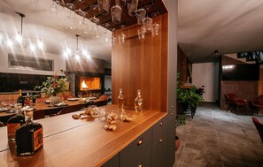 Ein moderner Essbereich mit einer Holztheke, Weingläsern und Flaschen.