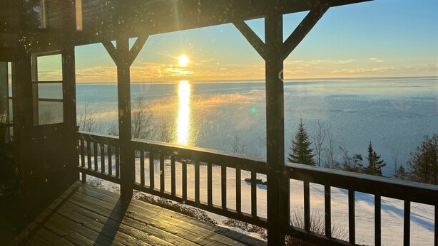 A wooden deck with a view of a body of water and a sunset. - Halsnoy Haven New Listing. Iconic property! (Tofte)