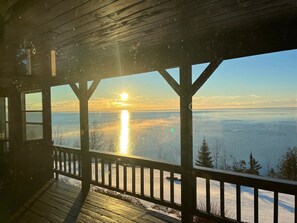 A wooden deck with a view of a body of water and a sunset. - Halsnoy Haven New Listing. Iconic property! (Tofte)
