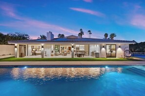 A modern house with a swimming pool, large windows, and a patio area. - Pura Vida - Luxe Estate w/ Pool, Spa & Pickleball! (Rancho Mirage)
