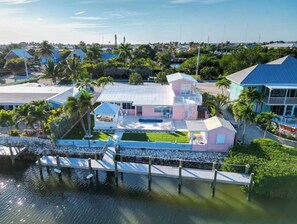 A coastal property with a dock, a swimming pool, and a large house with multiple levels. - Beach House 5BR/5BA, 1/2 mile to Sombrero Beach, Pool & 75ft Dockage, Newly Renovated (Marathon)