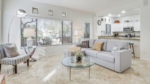 Een moderne woonkamer met een bank, fauteuil en glazen salontafel.