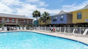 A swimming pool with a white fence and lounge chairs. - Pet Friendly Beach Access Sleeps 6 Hangout Nearby (Gulf Shores)