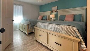 A bedroom with two beds, a ceiling fan, a nightstand, and a dresser. - Pet Friendly Beach Access Sleeps 6 Hangout Nearby (Gulf Shores)