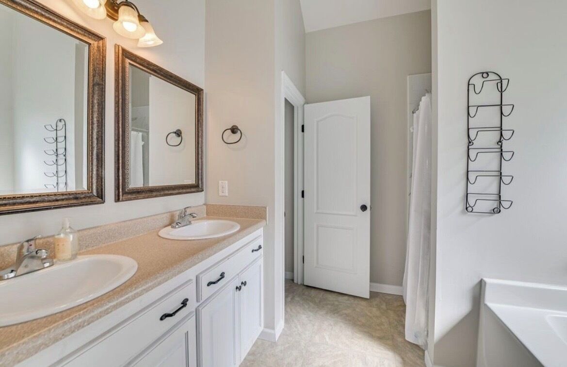 Une salle de bain avec deux lavabos, un grand miroir et une douche.