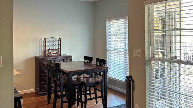 A dining area with a wooden table and chairs, a bar sign, and a window with blinds. - Master’s Rental - 2 weeks 3 bed/2bath - 3 miles from golf course Augusta, GA (Augusta)