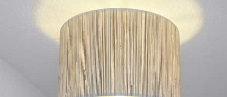 A ceiling lamp with a cylindrical shade and vertical slats.
