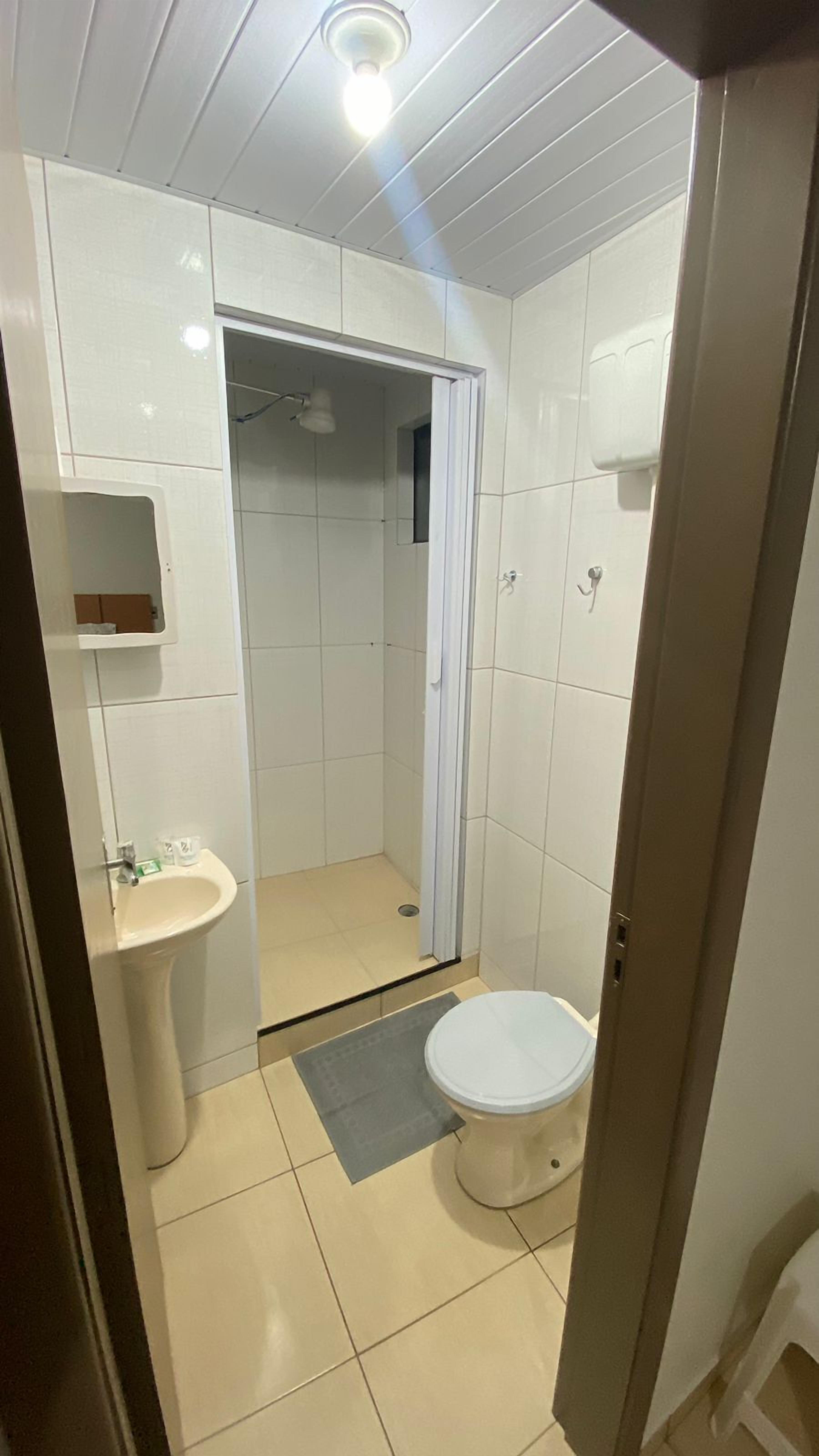 A small, clean bathroom with a toilet, sink, and shower.