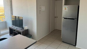 Una cocina compacta con refrigerador, una mesita y una ventana con vistas.