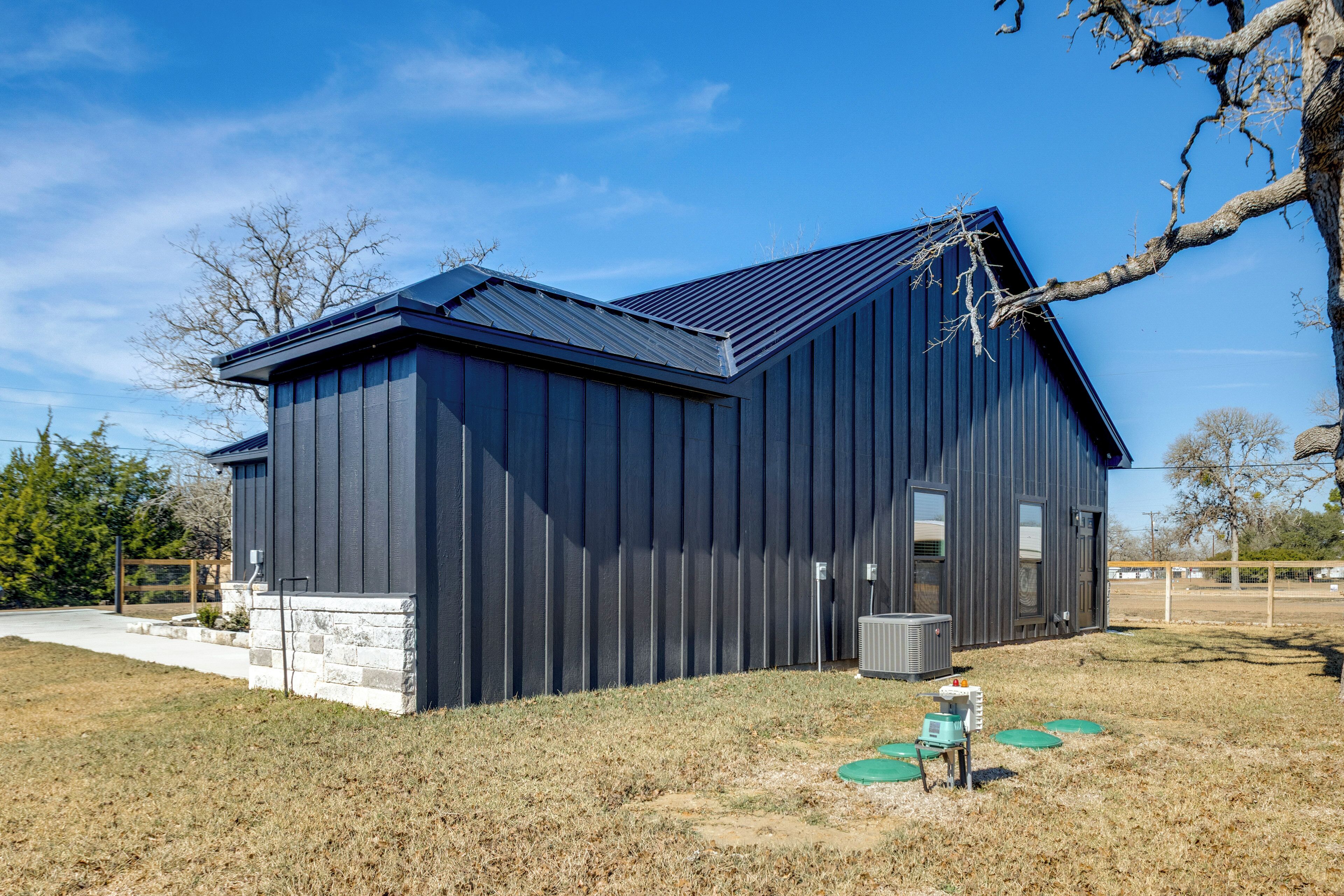 A modern building with a dark exterior, a sloped roof, and a small front porch.