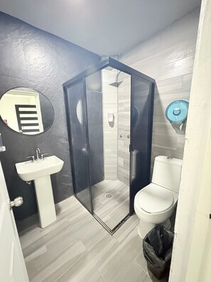 A compact bathroom with a shower enclosure, a sink, and a toilet. - Residencial Gran Cobae Triplex D (Tonalá)