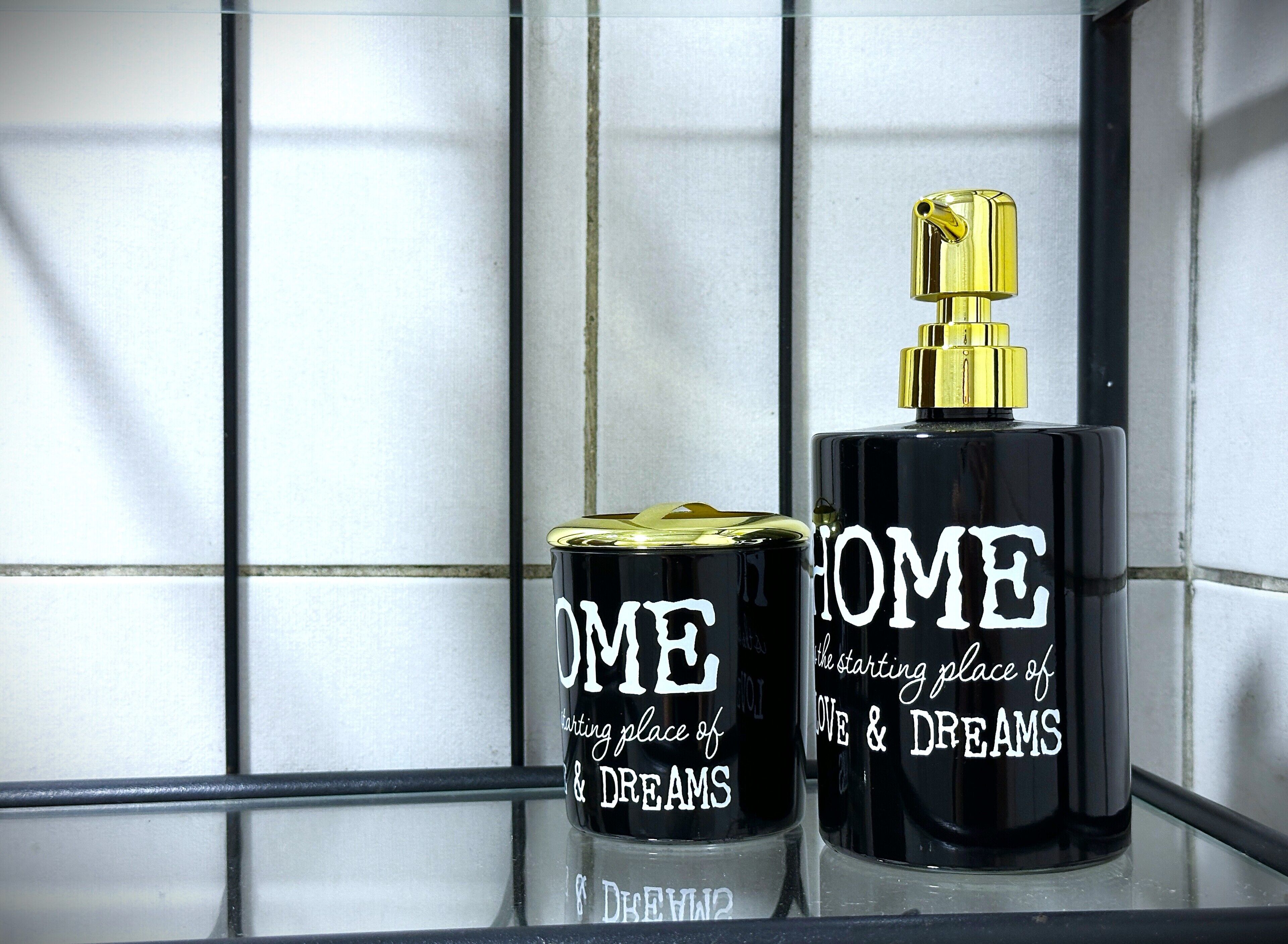 Two perfume bottles on a glass shelf with a tiled wall background.