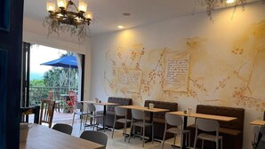 Ein modernes Café mit Holztischen und -stühlen, einem Chandelier und einem Wandgemälde.