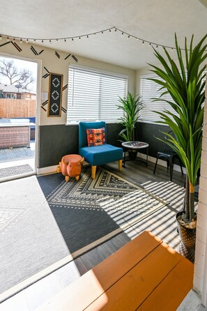 A cozy room with a blue sofa, a small table, a potted plant, and a patterned rug. - Arvada Getaway | Hot Tub | Fire Pit | Light Rail (Arvada)