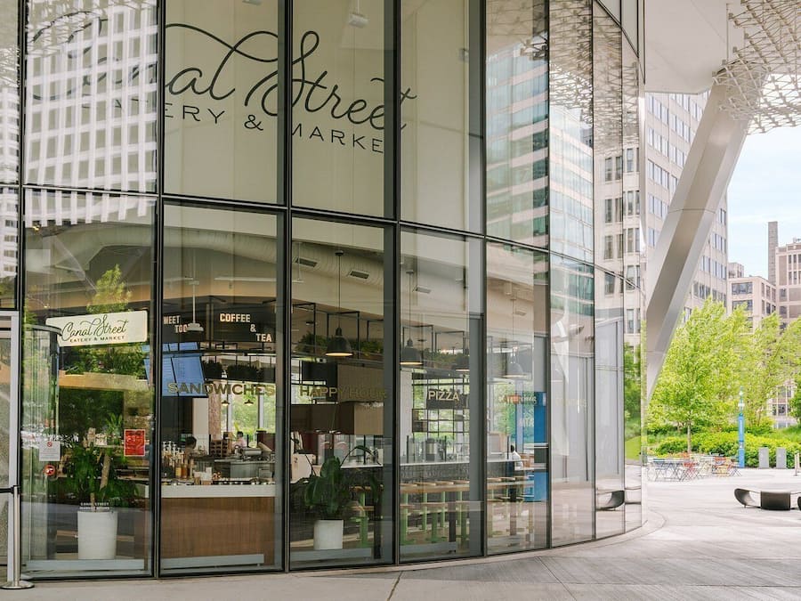 Un bâtiment moderne à la façade en verre, qui abrite un café appelé « Canal Street ».