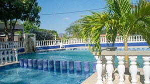 A swimming pool with blue tiles, white balustrades, and a palm tree. - Hotel Palmas del Rio Mompox (Mompos)